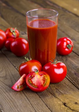 Tahta bir masada cam bir kavanozda domates suyu.