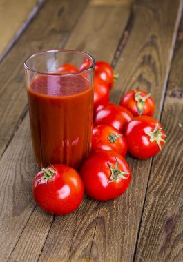 Tahta bir masada cam bir kavanozda domates suyu.