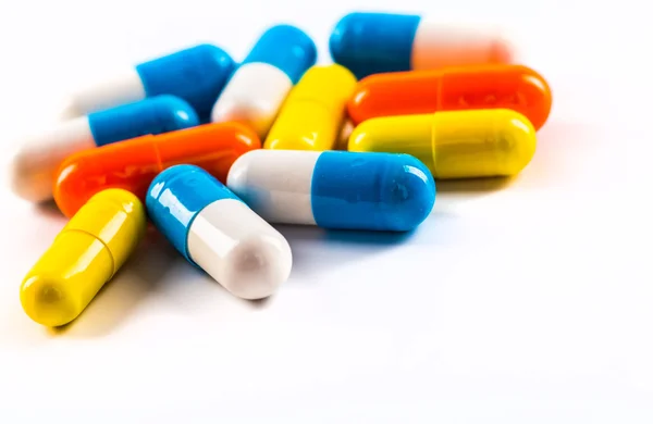 Medications tablets and capsules in a beaker — Stock Photo, Image