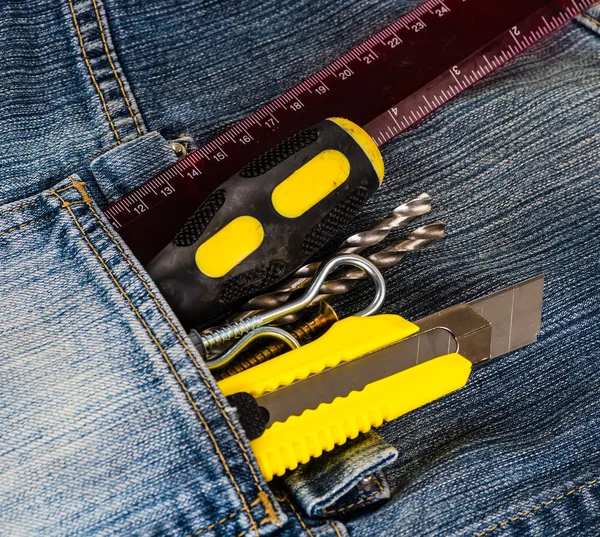 Ferramentas, chave de fenda, parafuso, faca estacionária em jaqueta jeans azul — Fotografia de Stock