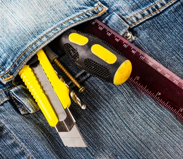 Ferramentas, chave de fenda, parafuso, faca estacionária em jaqueta jeans azul — Fotografia de Stock