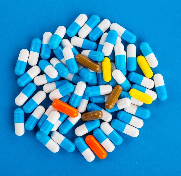 Medications tablets and capsules in a beaker — Stock Photo, Image