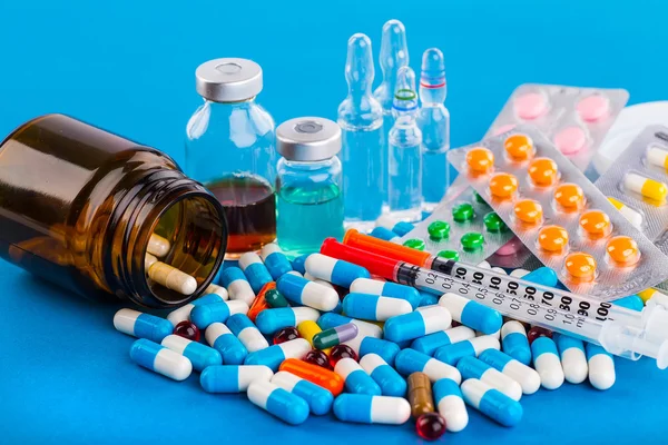 Medications tablets and capsules in a beaker — Stock Photo, Image