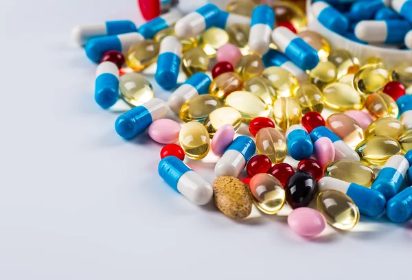 Medications tablets and capsules in a beaker — Stock Photo, Image