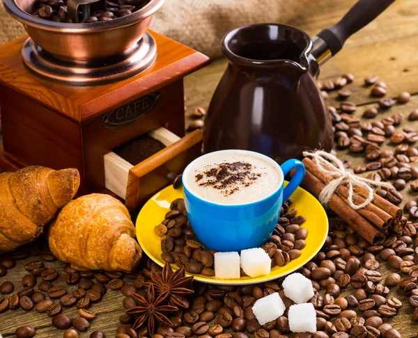 Taza de café y granos de café en la mesa — Foto de Stock