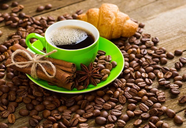 Primer plano de la taza de café con granos de café tostados en respaldo de madera — Foto de Stock