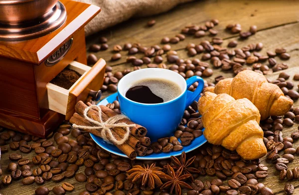 Primer plano de la taza de café con granos de café tostados en respaldo de madera — Foto de Stock