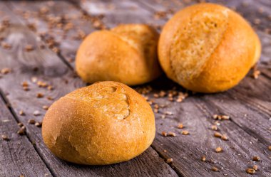 Ahşap masa arkasında pişmiş ekmek çeşitleri