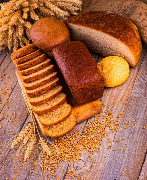 Свіжий хліб і пшениця на дерев'яній — стокове фото
