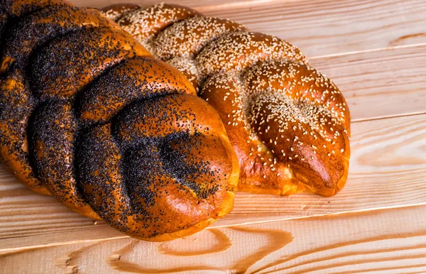 Two whole fresh challah bread with poppy and sesame on a wooden — Stock Photo, Image