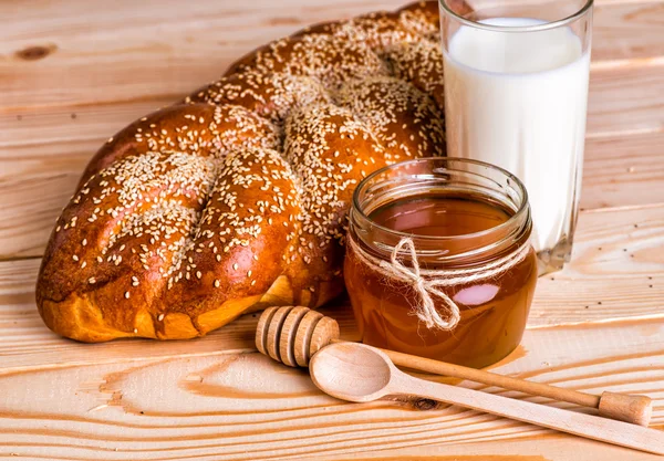 Смачні булочки з маком та кунжутом молоко та мед на дерев'яному фоні — стокове фото