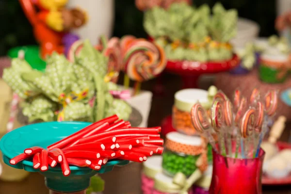 Πολύχρωμες καραμέλες και τα γλειφιτζούρια σε ένα τραπέζι κορίτσι γενεθλίων — Φωτογραφία Αρχείου