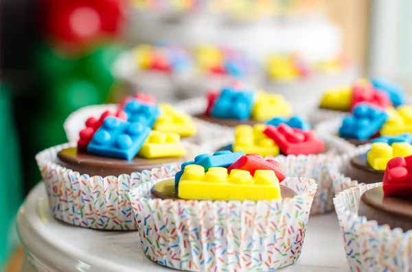 Coloridos bloques de construcción en cupcakes de chocolate — Foto de Stock