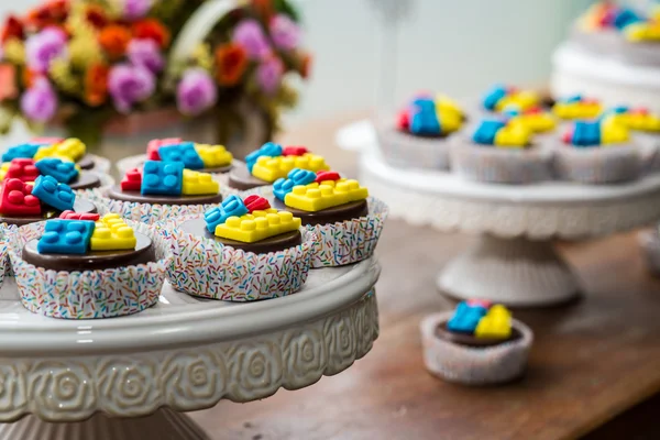Coloridos bloques de construcción en cupcakes de chocolate — Foto de Stock