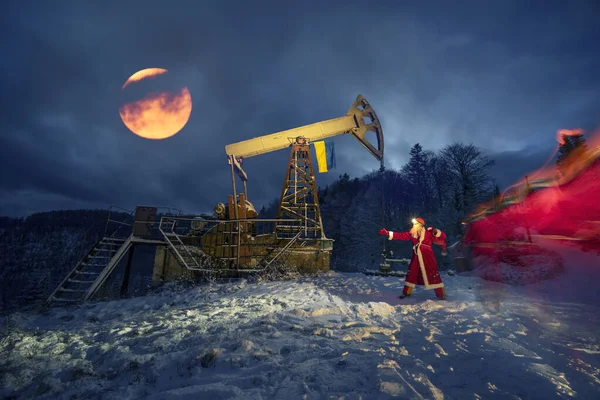 在喀尔巴阡山脉冬季的山上 圣诞老人在装有乌克兰国旗的油泵下给石油和天然气工人带来了一袋礼物 祝您新年快乐 运动模糊增加动力 — 图库照片