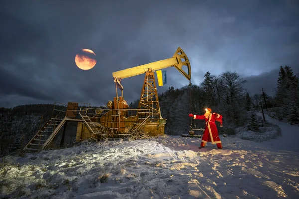 Santa Claus Přinesl Pytel Dárků Pod Ropné Čerpadlo Vlajkou Ukrajiny — Stock fotografie