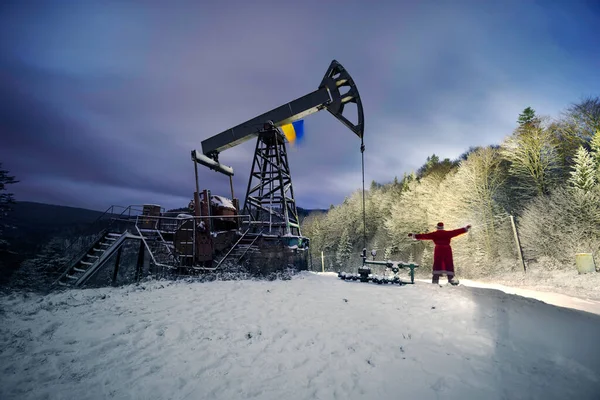 在喀尔巴阡山脉冬季的山上 圣诞老人在装有乌克兰国旗的油泵下给石油和天然气工人带来了一袋礼物 祝您新年快乐 — 图库照片