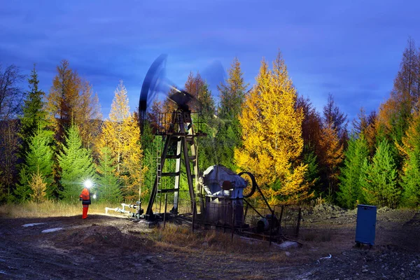 乌克兰喀尔巴阡山脉的一个古老的石油和天然气田 罗马尼亚水泵夜间在山坡上工作 戴着头盔和工作服的石油工程师检查燃料的提取 — 图库照片