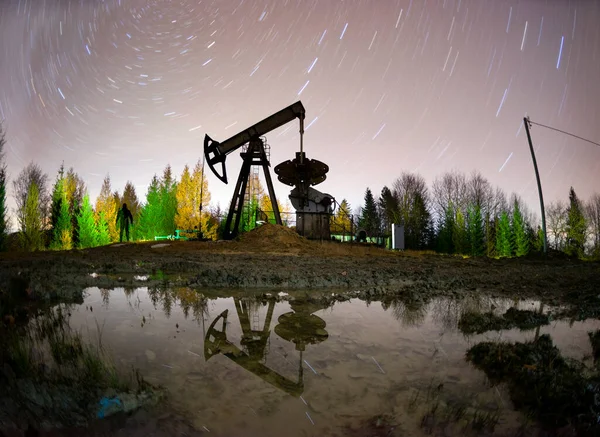 典型的罗马尼亚水泵在夜间工作在喀尔巴阡山脉的湖泊和沼泽地 乌克兰 星星和银河的星座象征着地球矿物资源的古老历史 — 图库照片