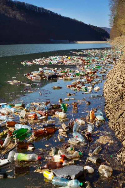 ウクライナのトランスカルパティアでの環境災害 山間部の村の住民は プラスチック廃棄物を直接川に投げ込み 貯水池に持ち込み その銀行に投棄します 生態系が低い コンクリートダム — ストック写真
