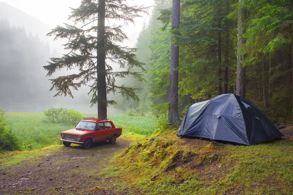 Красный автомобиль и палатка после дождя — стоковое фото