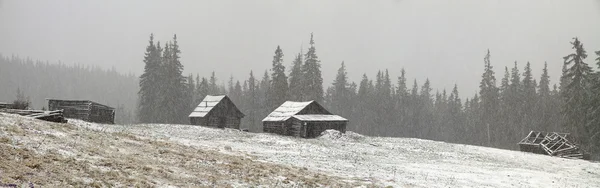 Будинки в горах на снігопаді — стокове фото