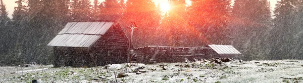 Casas em montanhas em queda de neve — Fotografia de Stock