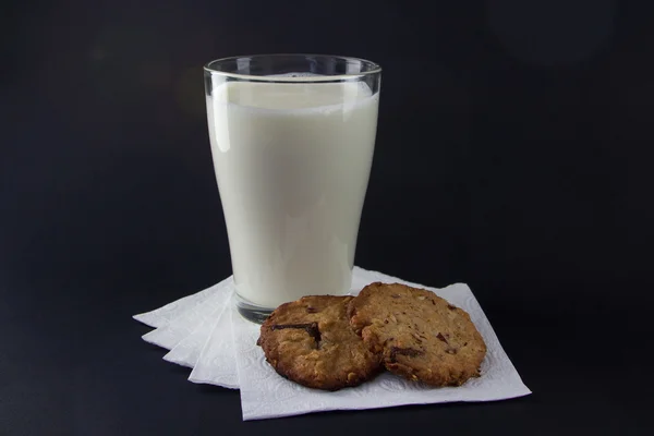 Glas mjölk på våtservetter med havremjöl kakor Stockbild