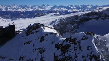 People Walking Across the Suspension Bridge on Glacier 3000 with Cable Car Station and Peak Walk in the Swiss Alps.