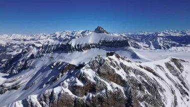 People Walking Across the Suspension Bridge on Glacier 3000 with Cable Car Station and Peak Walk in the Swiss Alps.