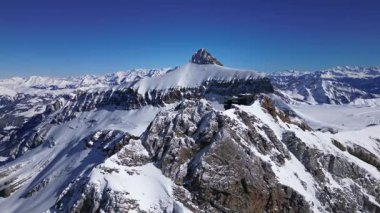 People Walking Across the Suspension Bridge on Glacier 3000 with Cable Car Station and Peak Walk in the Swiss Alps.