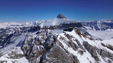 People Walking Across the Suspension Bridge on Glacier 3000 with Cable Car Station and Peak Walk in the Swiss Alps.