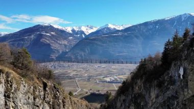 Passerelle Farinet üzerinden yürüyen turistler, güzel güneşli bir günde İsviçre Alpleri manzaralı Salentse Vadisi 'nin üzerindeki tahta köprü.