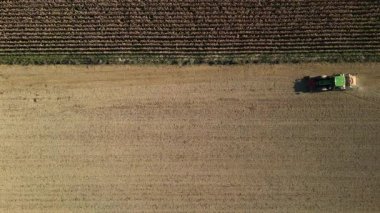 Traktörün hava aracı görüntüsü arkadaki tohum ekme makinesiyle ekin ekimi güney kırsalındaki büyük tarım arazisine modern tarım tarlası operasyonları