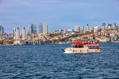 İstanbul 'un modern gökdelenleriyle birlikte gökdelenlerin arasından geçen Boğaz teknesi