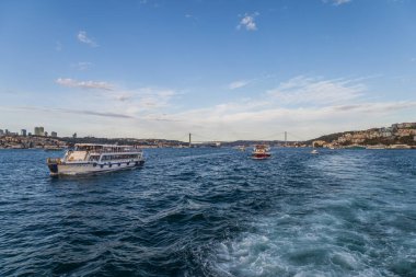 Boğaz feribotu, boğaz köprüsü ve kıyı manzarası ile çalkantılı bir iz bırakıyor.