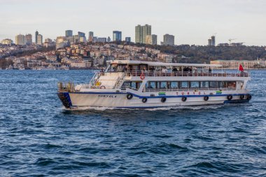 Turyol feribotu günbatımında modern İstanbul siluetini geçerek Boğaz 'dan geçiyor.