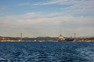 Günbatımında Boğaziçi Köprüsü 'nün altından geçen büyük konteyner gemisi (15 Temmuz Şehitler Köprüsü)