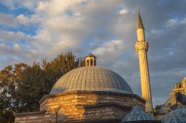 İstanbul 'da günbatımında tarihi Osmanlı hamamı (Hamam) kubbesi ve cami minaresi