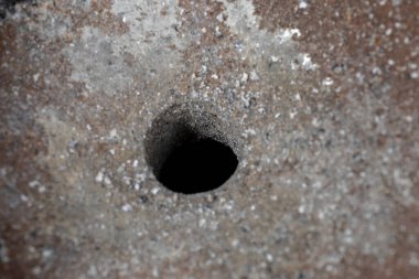 Kaba bir doku yüzeyinde delinmiş bir deliğe yakın çekim..