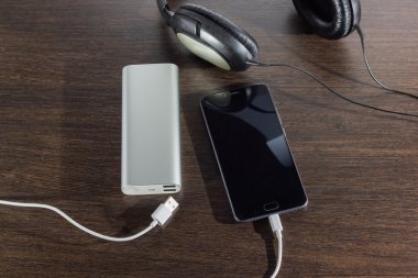 koyu arka plan üzerinde cep telefonu ve güç banka pil