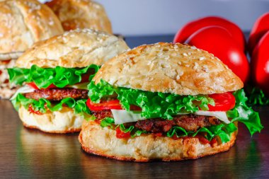 Ev yapımı hamburgerler ahşap masada.