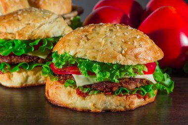 Ev yapımı hamburgerler ahşap masada.