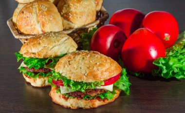 Ev yapımı hamburgerler ahşap masada.
