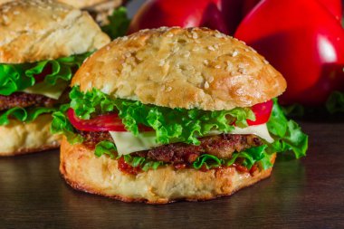 Ev yapımı hamburgerler ahşap masada.