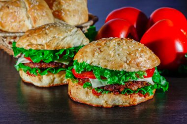 Ev yapımı hamburgerler ahşap masada.