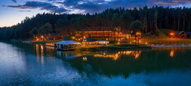 Göl kenarındaki sisli sabahın havadan görünüşü ve alacakaranlıkta evleri.,