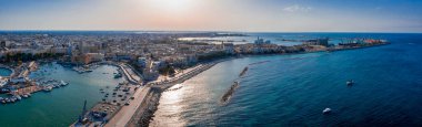 Gün batımında Bari Apulia City liman botları ve yatları, Deniz Kıyısı, Teatro Margherita ve Bari şehrinin ufuk çizgisine uçan insansız hava aracının güzel panoramik görüntüsü..