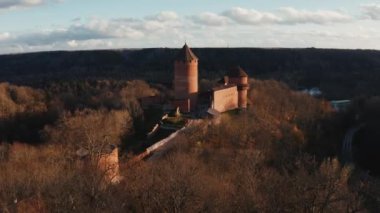 Turaida Kalesi 'nin altın saatinde güzel bir hava manzarası var. Sigulda, Letonya 'da gün batımı. Turistik bir yer. Tepenin üstündeki ortaçağ şatosunun havadan görünüşü. 