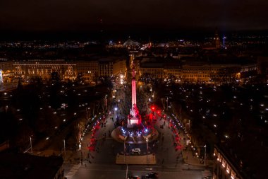 Riga, Letonya - 18 Kasım 2020: Riga, Letonya 'da Staro Riga etkinliği sırasında gece özgürlük abidesi. Milda - Özgürlük heykeli şehrin üzerinde üç yıldız tutuyor farklı renklerde aydınlatılmış.